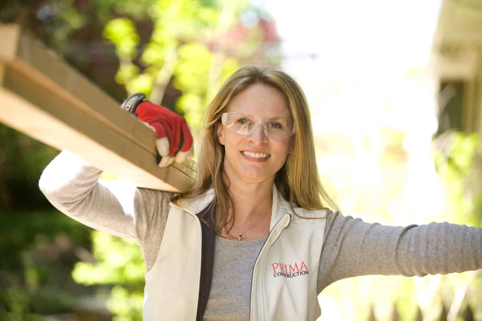 Kim Studham carrying a beam on a Prima Construction job site