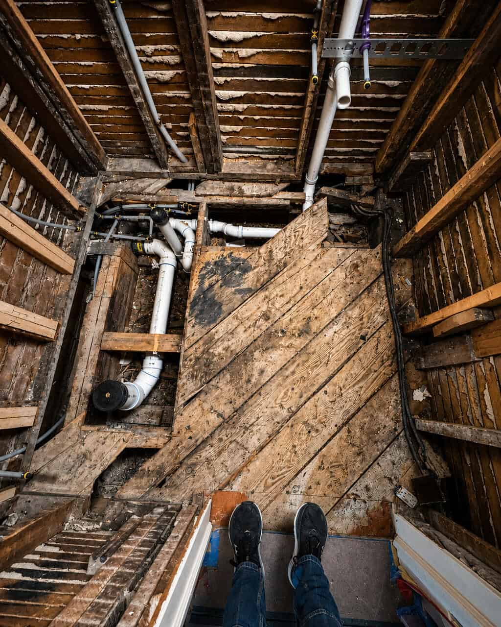Interior view of a construction site showing plumbing and framing work by a woman-owned company.